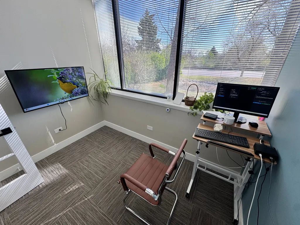 Neurofeedback training room with a wall-mounted screen and EEG workstation at Dody Chiropractic